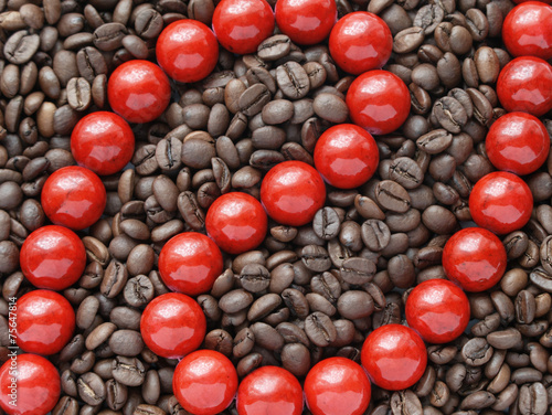 Glossy red beads in brown coffee beans