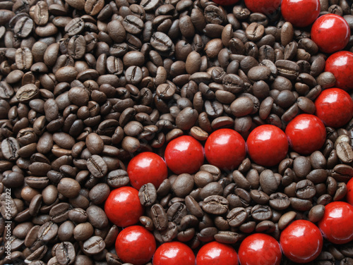 Glossy red beads in brown coffee beans