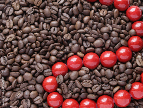 Glossy red beads in brown coffee beans