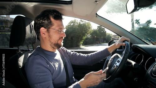 Funny man texting message with cell phone while driving