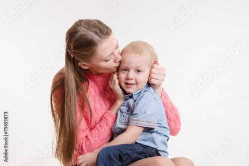 Young mother kissing her son three years