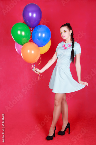 Portrait of a young attractive woman holding bunch of balloons © art_zzz