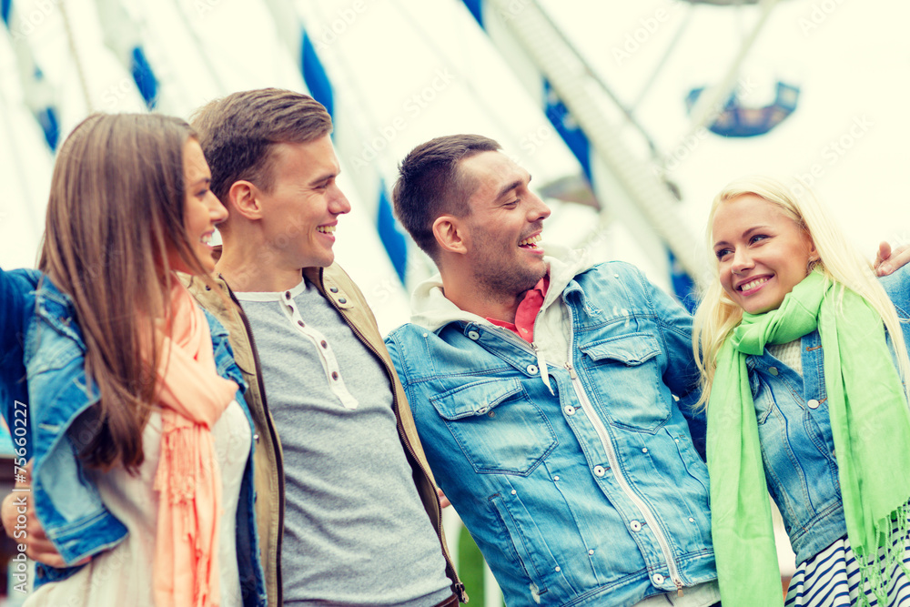group of smiling friends in amusement park group of smiling friends in amusement park