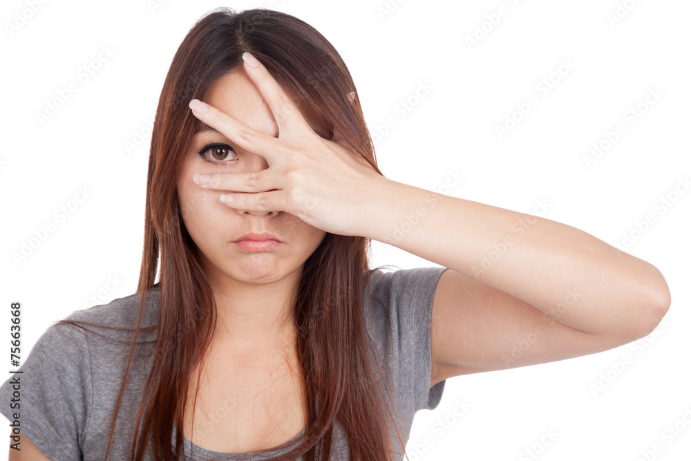 Young Asian woman peeking though her fingers Young Asian woman peeking though her fingers