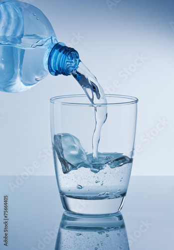 Mineralwasser in Wasserglas leeren