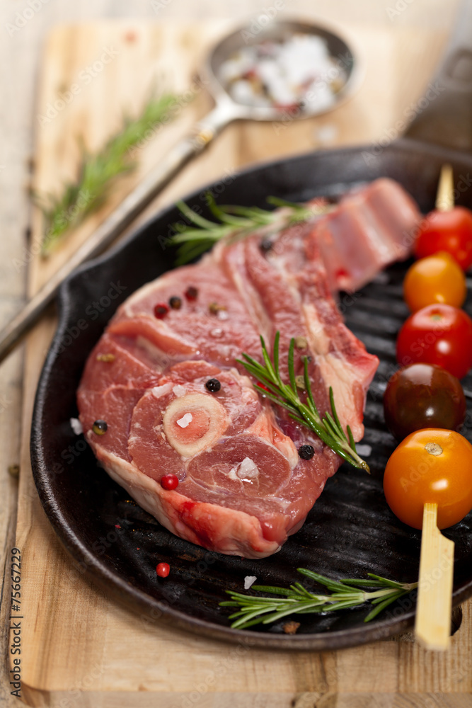 Raw lamb chops with cherry tomato and rosemary ready to cook
