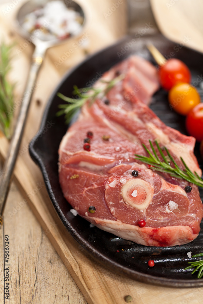 Raw lamb chops with cherry tomato and rosemary ready to cook Raw lamb chops with cherry tomato and rosemary ready to cook