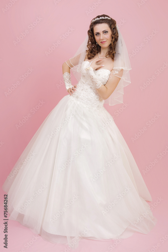 beautiful bride is standing in wedding dress on pink background beautiful bride is standing in wedding dress on pink background