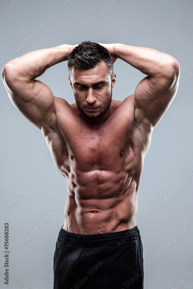 Healthy muscular man standing over gray background Healthy muscular man standing over gray background