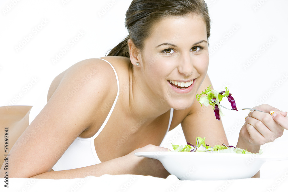 portrait of lying down woman eating salad portrait of lying down woman eating salad