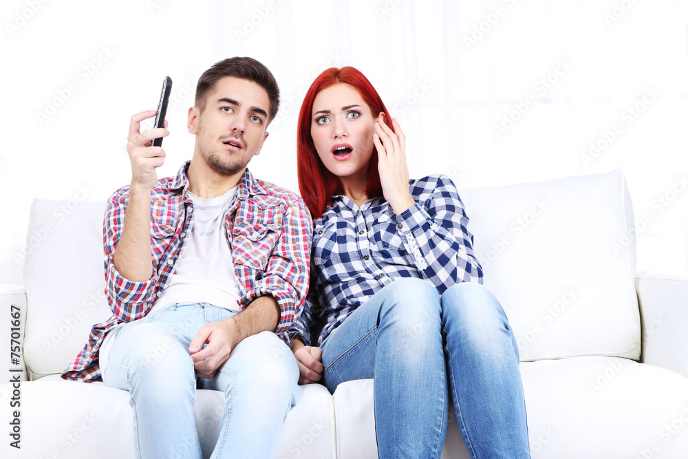 Young couple watching television at home Young couple watching television at home
