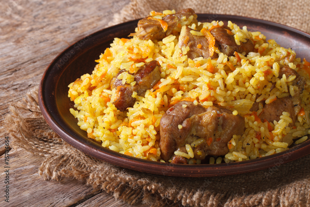pilaf with meat and vegetables close up on a plate. horizontal pilaf with meat and vegetables close up on a plate. horizontal