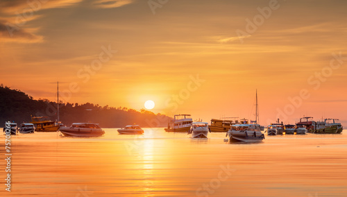 sunrise with colorful sky and boats on the beach