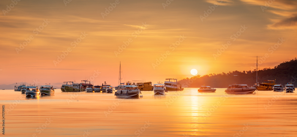 sunrise with colorful sky and boats on the beach