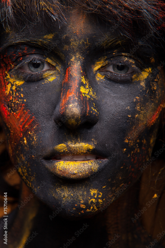 Fototapeta premium dark portrait of woman in black paint with yellow smudges