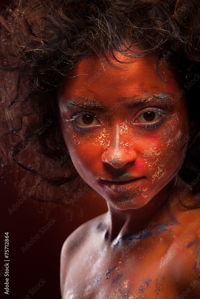 young woman with creative red  face-art and afro hair