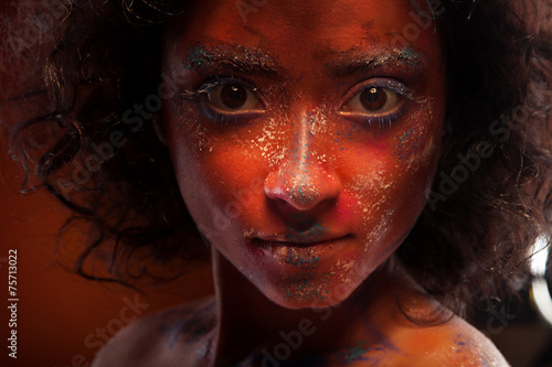 young woman with creative red face-art and afro hair