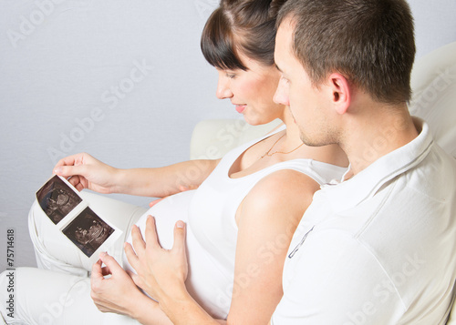 Young couple looking at their baby ultrasound picture photo