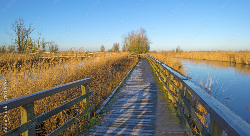 Wooden bridge with hoarfrost along a river