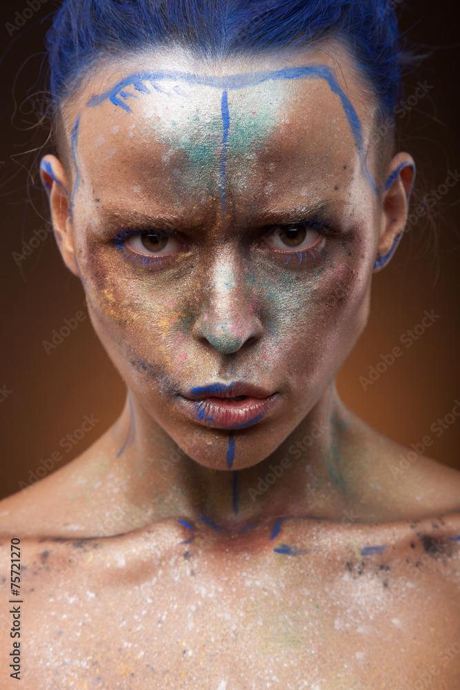 Portrait of a woman who is posing with blue and gold paint Portrait of a woman who is posing with blue and gold paint