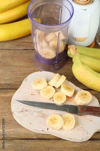 Fototapeta Naklejka Na Ścianę i Meble -  Sliced banana on cutting board, on wooden background