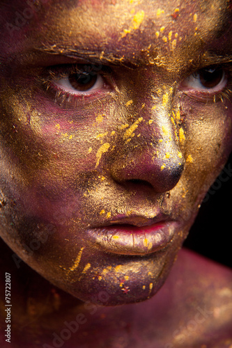 Girl with gold paint on face with face art and body art © Dmytro Sandratskyi