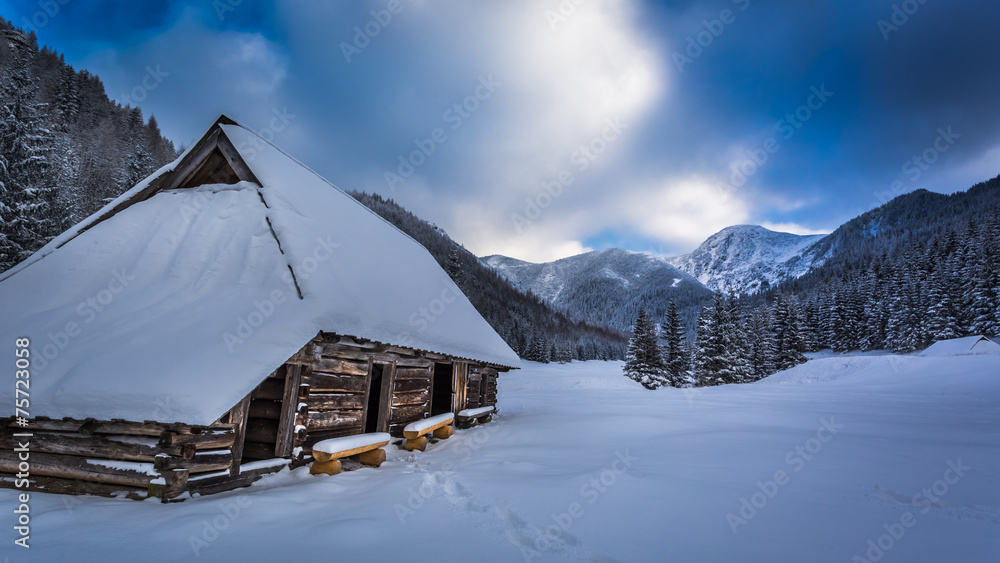 Old wooden hut in winter mountains