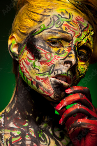 woman with face-art and body art paint. Like bird. Feather
