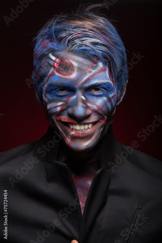 A creepy portrait of a man with bloody body art and face art