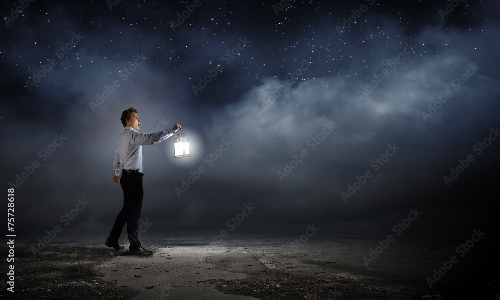 Businessman in search in darkness Businessman in search in darkness