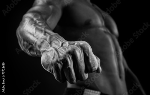 Handsome muscular bodybuilder demonstrates his fist and vein