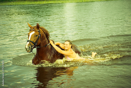  woman swimming winth stallion in river