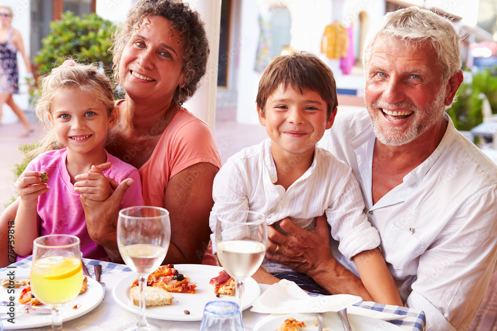 Grandparents With Grandchildren Eating Meal At Restaurant