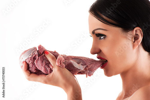 hungry woman eating raw meat in hand