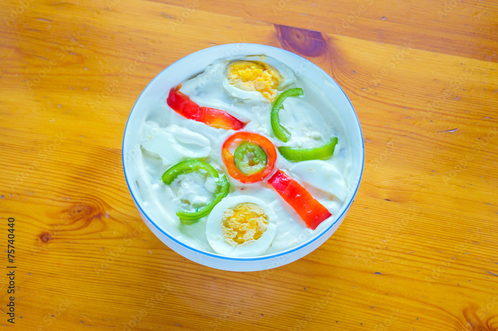 Greek salad with eggs, cheese, yogurt and vegetables