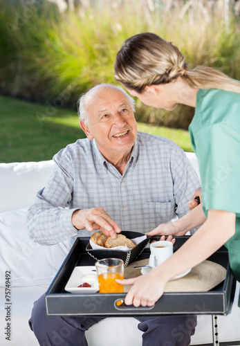 Konstfotografi Female Caretaker Serving Breakfast To Senior Man