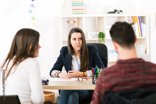 Young woman working at her desk with clients