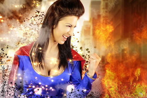 фотография young woman dressed as a superhero shows its power