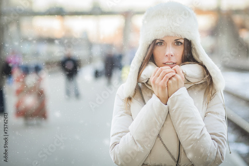 Youn woman on a train station in winter