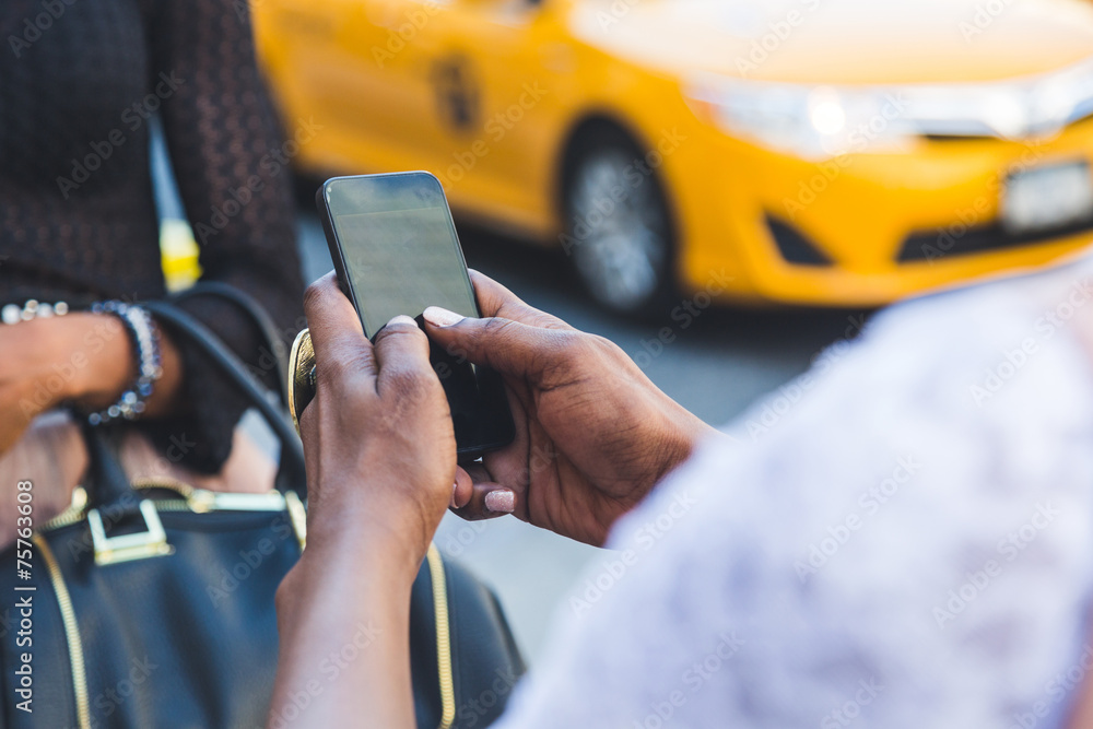 Two Beautiful Black Woman Using Smart Phone in New York