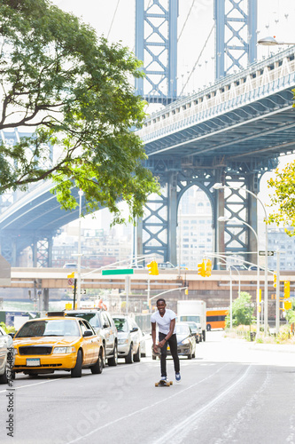 Photography Black Boy Skating with Longboard on the Road
