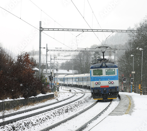 Czech train station at winter with train in a snowstorm