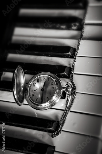 Pocket watch on old keyboard piano