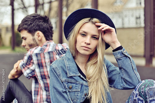 Depressed couple. Depressed young hipsters couple sitting back t photo