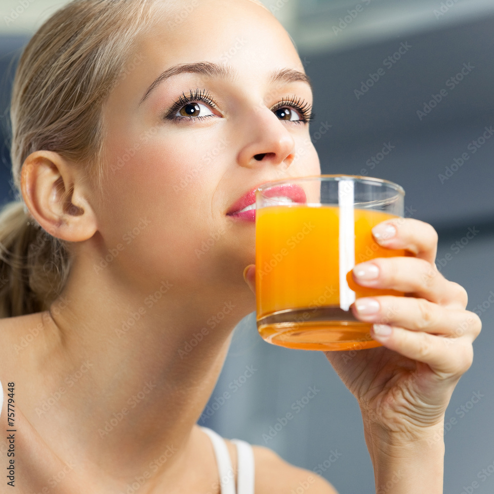 Young beautiful woman drinking orange juice, indoors Young beautiful woman drinking orange juice, indoors