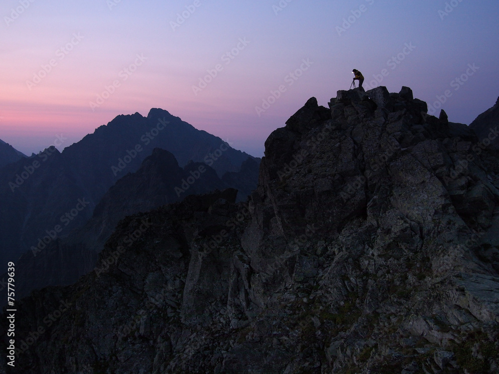 Silhouette of the photographer on top of a rock shield at dawn