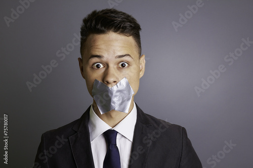 Businessman with tape over  mouth