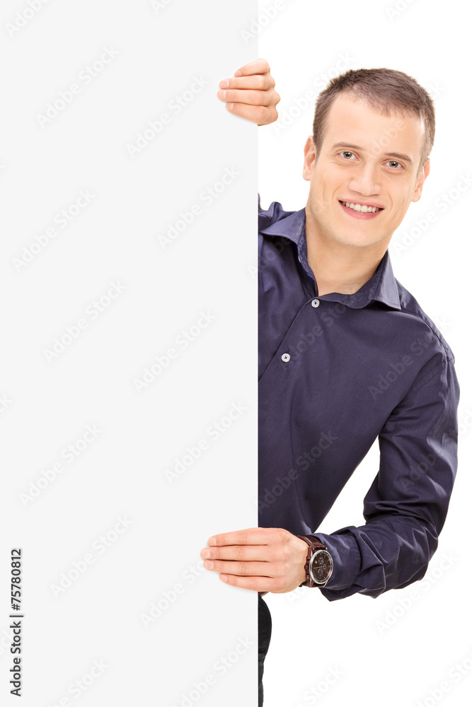 Cheerful young guy posing behind panel Cheerful young guy posing behind panel