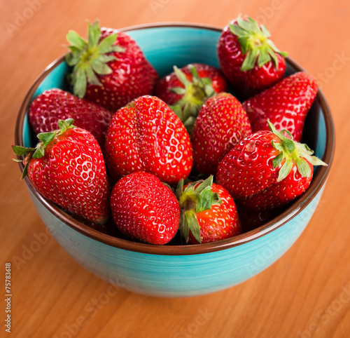 Strawberries in a Bowl  ona a wooden background