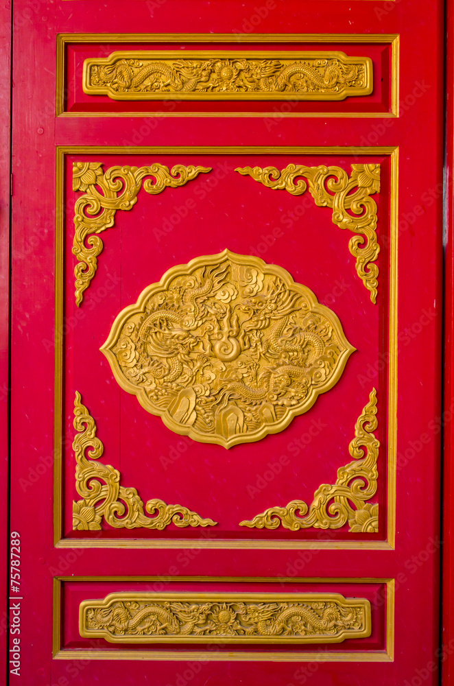 Red door with dragon statue in Thai-Chinese temple.